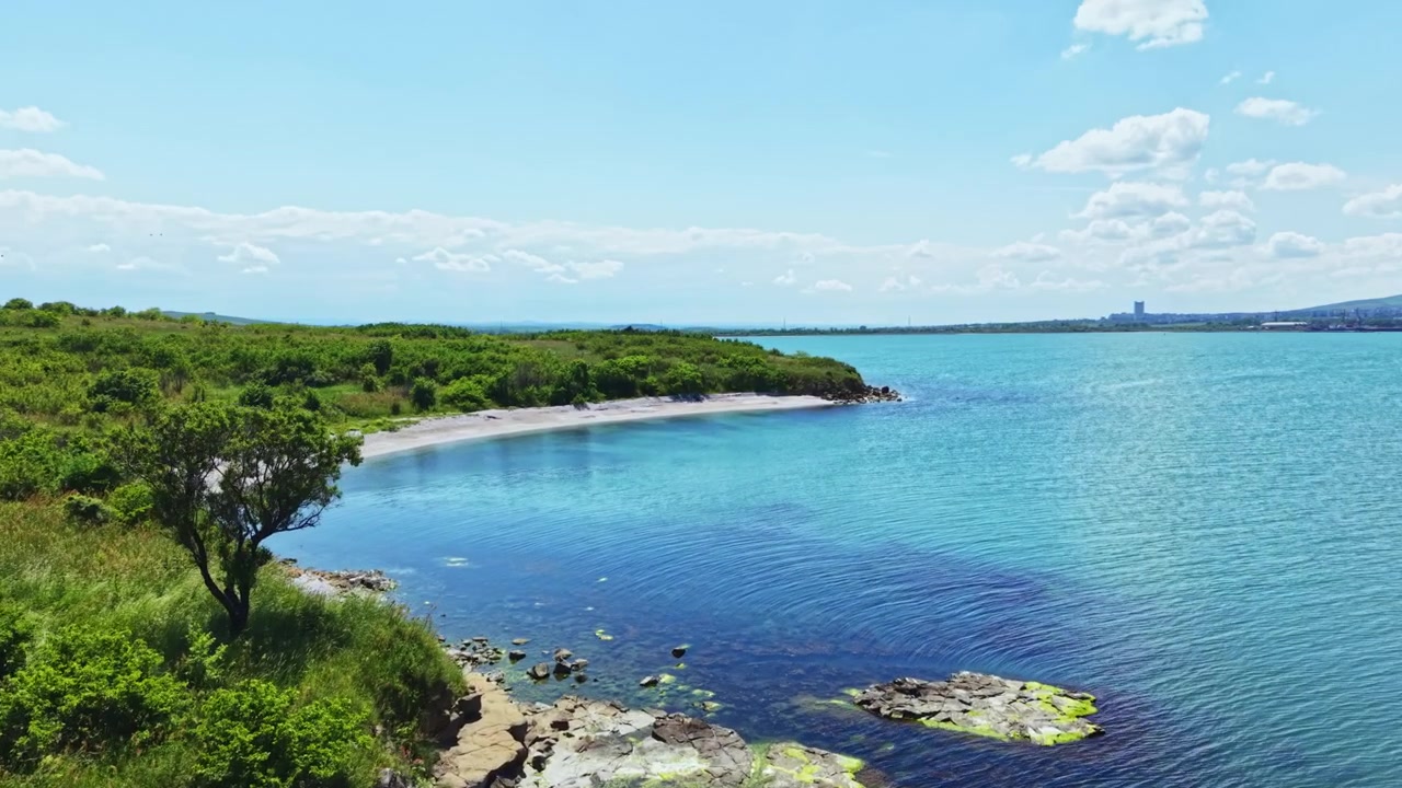 穏やかな海岸風景。豊かな自然に囲まれた平和な湾。鮮やかな緑と岩の多い海岸のそばの穏やかな水面。自然の美しさを捉えた静かな湾の絶景ドローン撮影