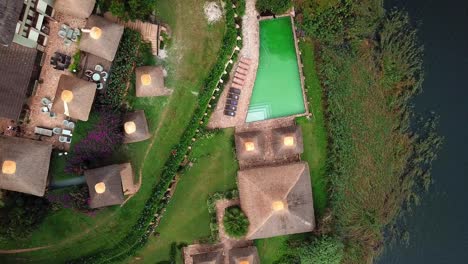 Vista-De-Arriba-Hacia-Abajo-De-La-Piscina-En-El-Complejo-Birdnest-En-El-Lago-Bunyonyi,-Uganda---Tiro-Con-Drones