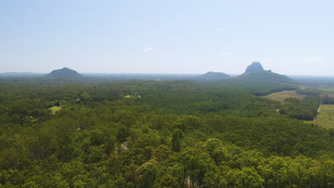 aerial drone flyover australian countryside, glasshouse mountains green forest, 4k