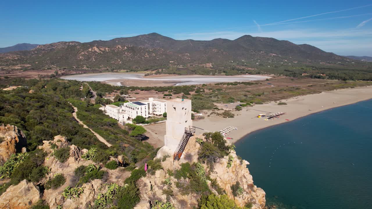 vuelo de avión no tripulado sobre una bahía con una torre en primer plano