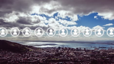 animation of a row of pulsating people icons moving across cloudy sky, coast and sea