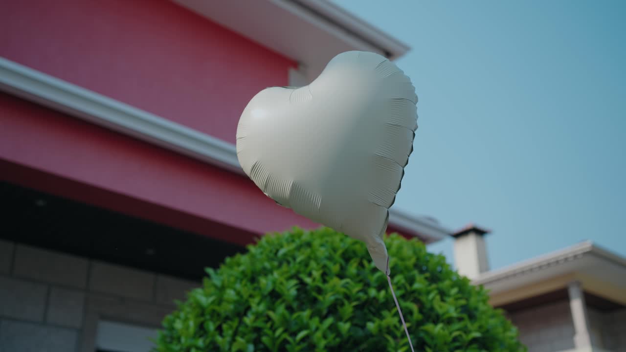 화창한 날에 하트 모양의 흰색 풍선이 밖으로 떠다니고 있어요