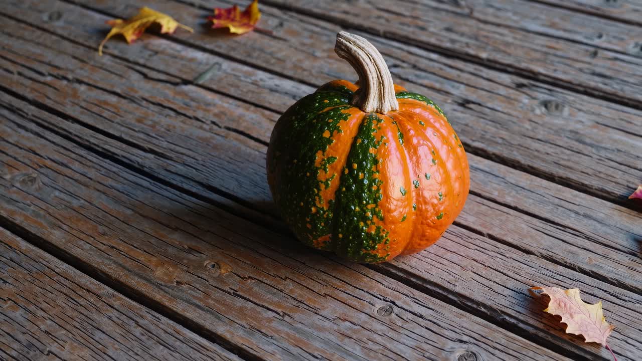 A small pumpkin on rustic wooden planks, captured from a high-angle