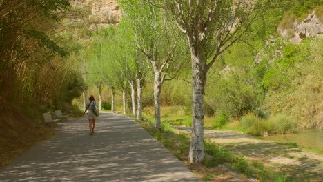 Eine-Frau,-Die-Auf-Einer-Gepflasterten-Straße-Zu-Den-Thermalbädern-In-Fuente-De-Los-Baños,-Montanejos,-Spanien,-Geht