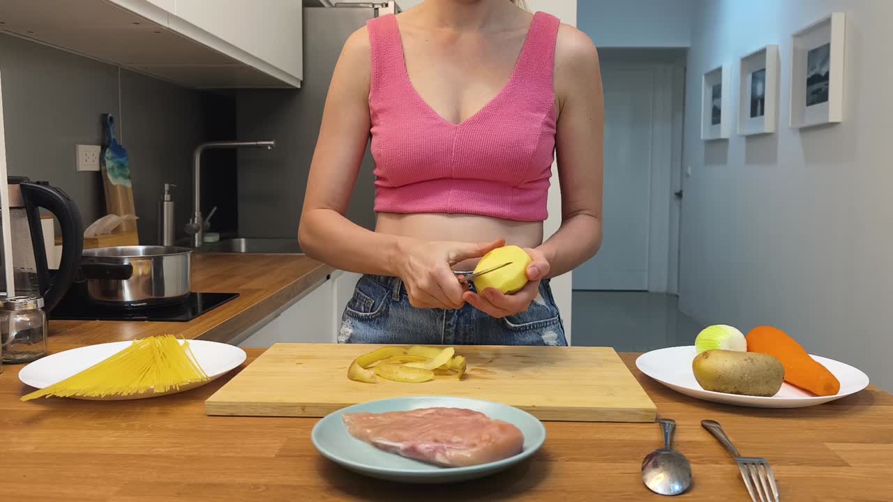mujer pelando patatas en la cocina