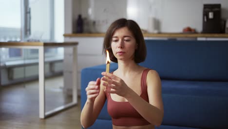 mujer encendiendo un fuego incienso hierbas e incienso, agitando