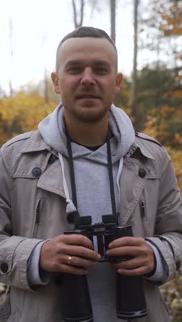 man with binoculars at the forest