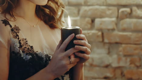 witch guessing with candle. closeup of witch woman holding candle for ritual in room