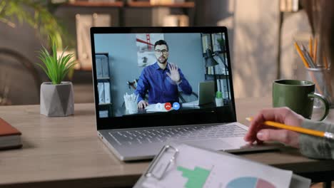 Female-Worker-Having-Business-Video-Conference-With-Male-Boss-And-Writing-Down-Information-In-Cabinet