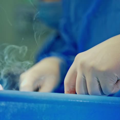 surgical instruments in doctor's hands. light smoke goes up during the operation. surgical procedure in the intensive care unit. close-up.