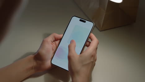 close-up of hands holding and interacting with a smartphone
