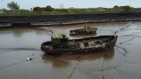 cinematic aerial view of a stranded old boat wreckage off the river