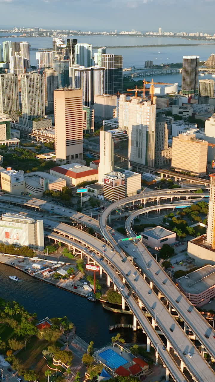 Miami, Florida, USA - January 05, 2024: Downtown Miami at orange sunset. Aerial view of downtown urban landscape of coastal bay city at dusk. Vertical video