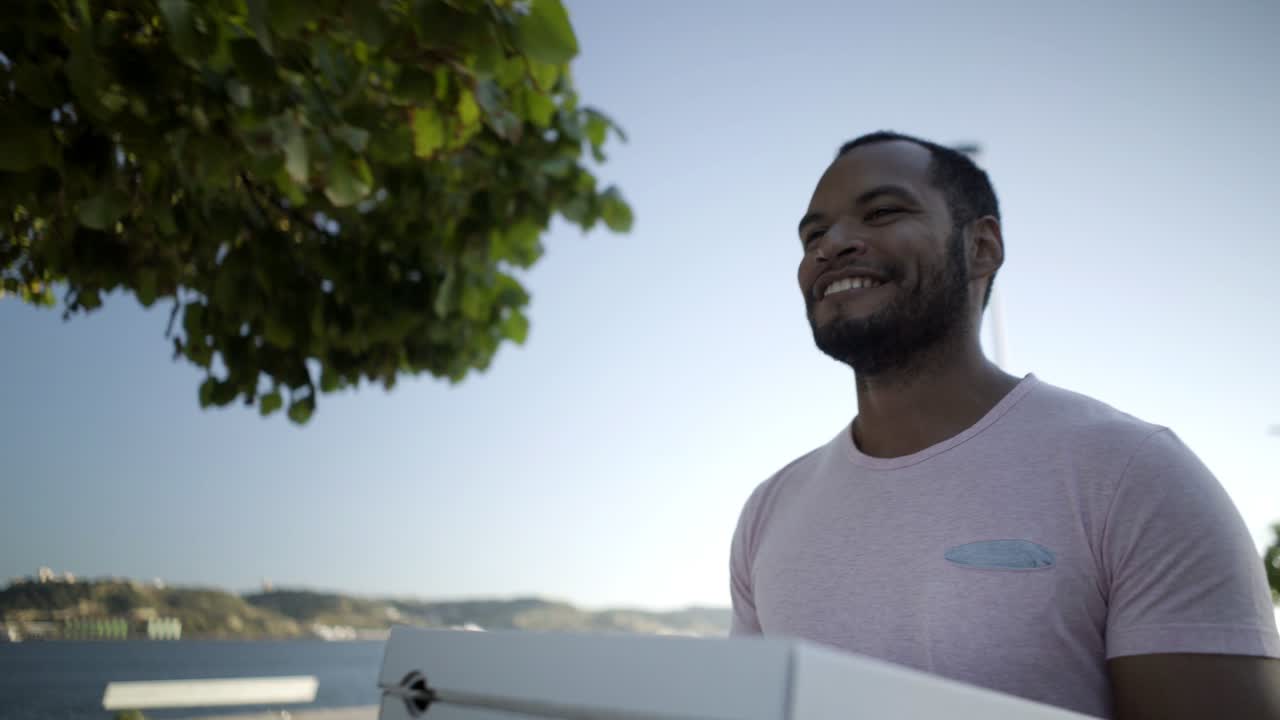 Smiling man holding pizza boxes