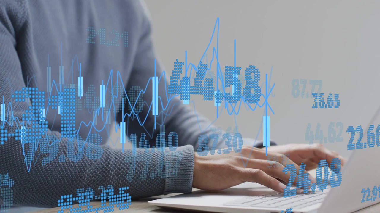 Uomo seduto alla scrivania che inizia a digitare, con le mani che premono i tasti, aggiornando grafici e numeri finanziari.