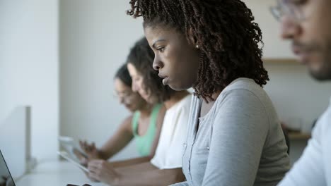 Seitenansicht-Einer-Nachdenklichen-Jungen-Frau,-Die-Im-Büro-Auf-Dem-Laptop-Tippt