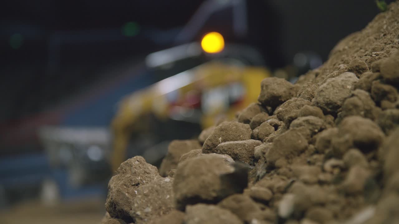 Close-up of Dirt Pile on Construction Site with Blurred Heavy Equipment