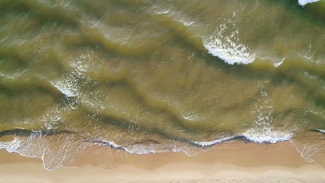 tropical beach aerial view, top view of waves break on tropical white sand beach. sea waves seamless loop on the beautiful sand beach.