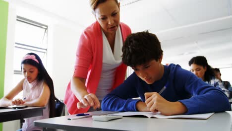 maestro ayudando a los estudiantes con su trabajo de clase
