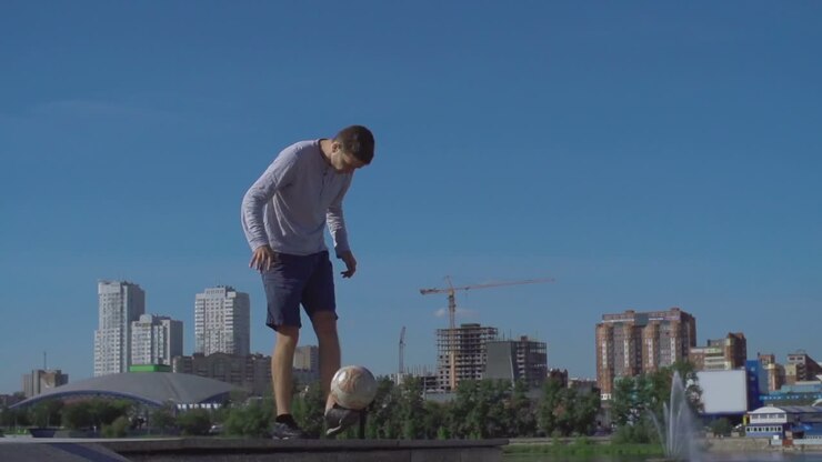 Young Athlete Man Playing With Soccer Ball In The City