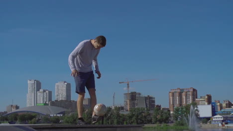 young athlete man playing with soccer ball in the city