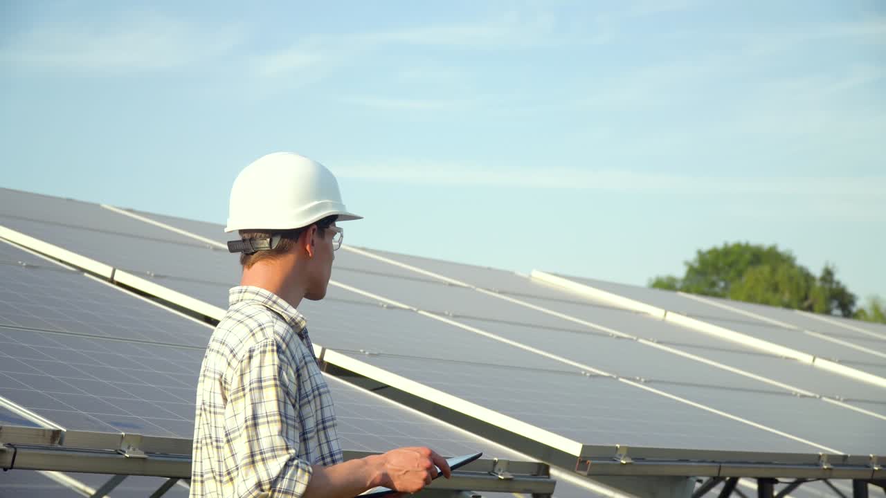 Solar panel technician working with solar panels. Engineer with a tablet checks solar panels productivity. Alternative energy concept