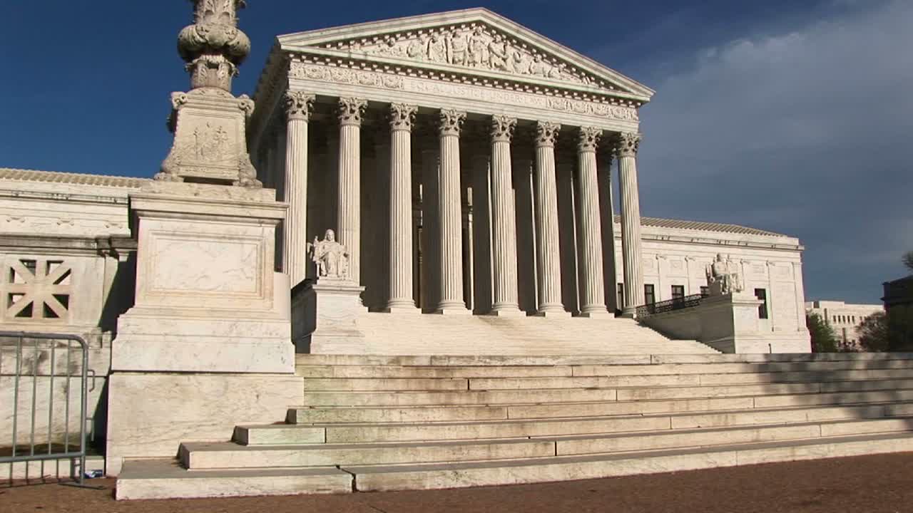 미국 대법원 건물 입구의 하얀 돌계단과 밝은 흰색 기둥에 햇빛이 반사된다