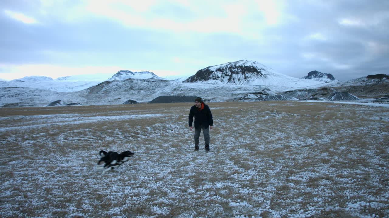 Pure happiness and joy reflected by energetic dog and owner playing outside during a cold snowy day