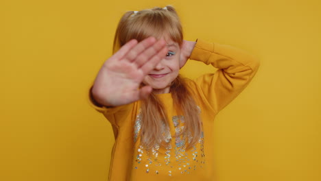 una niña linda cubriendo sus orejas y sonriendo