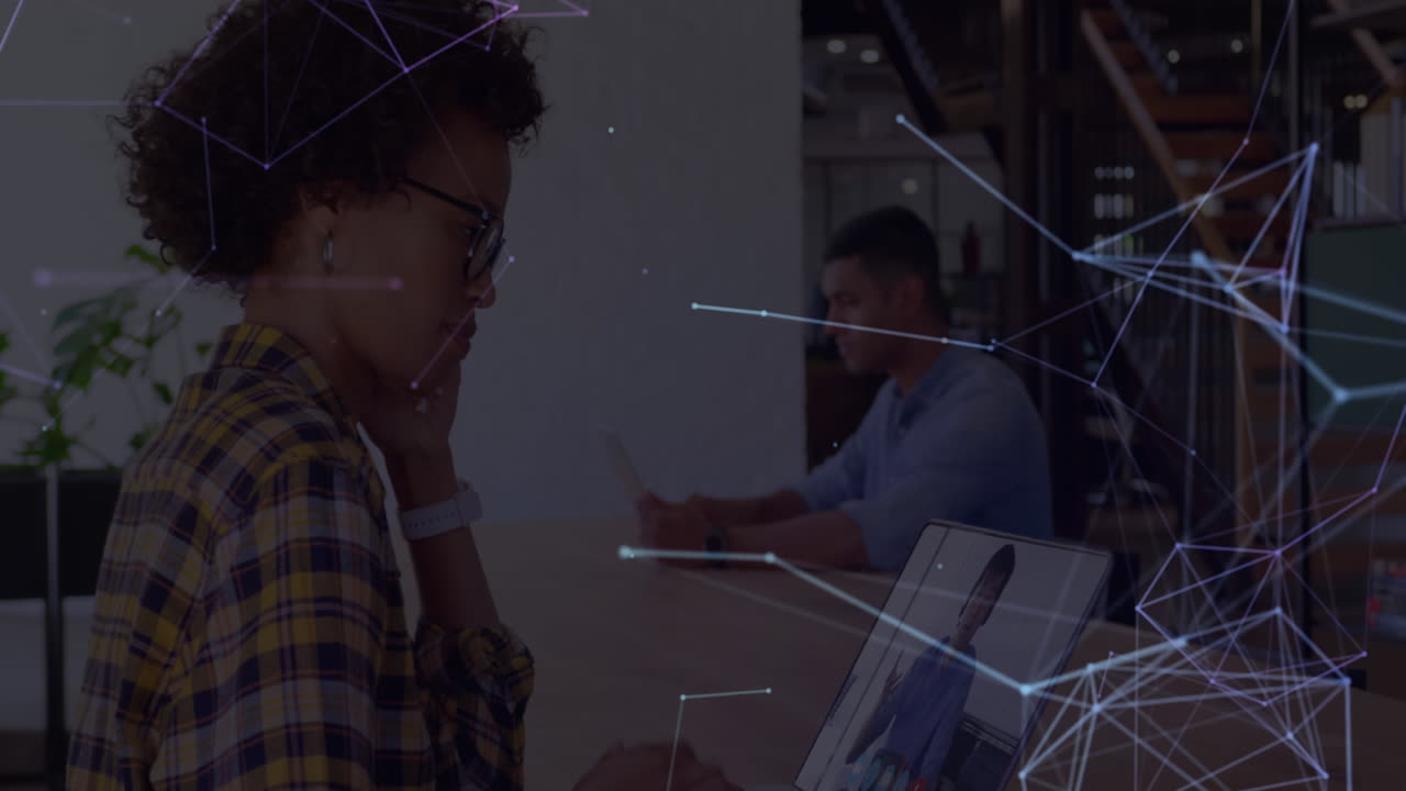 red de conexiones a través de una mujer biracial usando una computadora portátil.