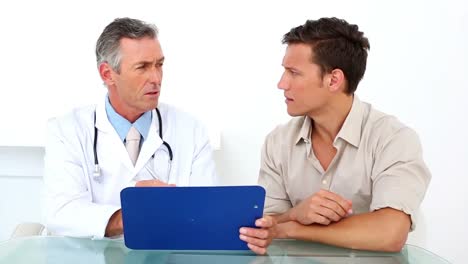 paciente escuchando a su médico sosteniendo el clipboard
