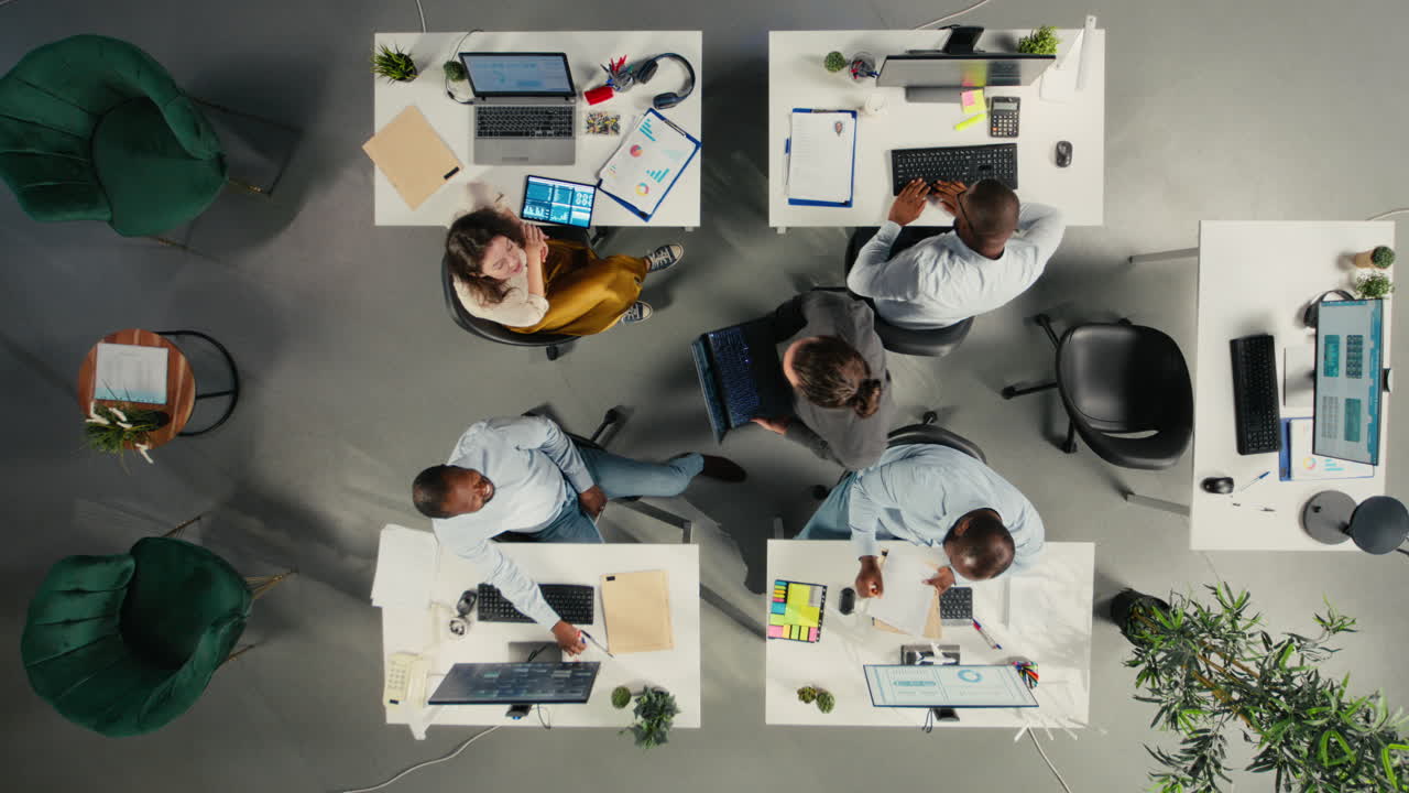 Vertical Video Top down view of coworkers engaged in consulting and report sharing at office