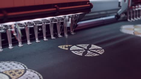 machine stitching intricate floral design on black textile surface