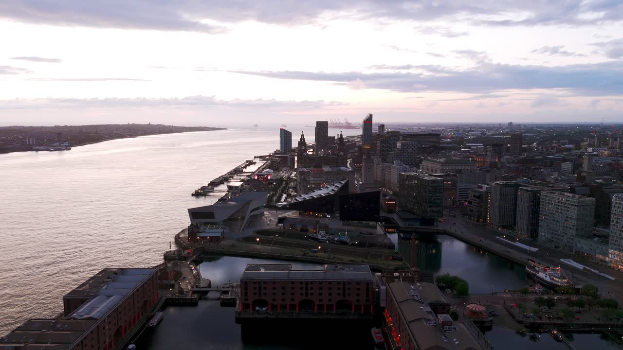 Aerial view of Liverpool's historic docks and modern buildings at sunset, showcasing the city's vibrant waterfront