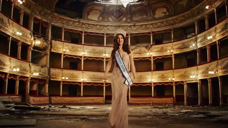 a spectacular moment in an abandoned theater: a stunning beauty pageant contestant gracefully walking and celebrating amidst the ruins of once grand architecture