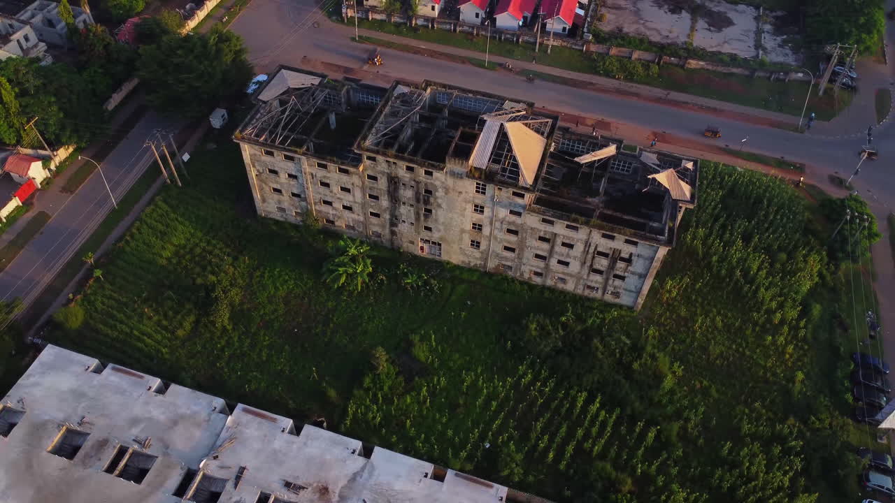 Stunning aerial view of an old and devastated building in a city in Nigeria. The structure's roof is missing and the top floor can be seen from the air