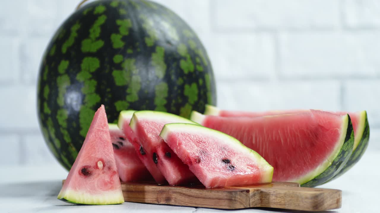sandía cortada y entera en la mesa girando lentamente.