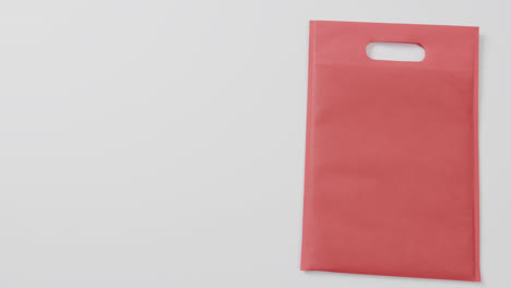 close up of red bag on white background, copy space, slow motion