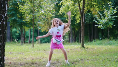 girl dancing on the meadow. happy girl having fun jumping outdoor at park
