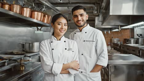 two smiling chefs in a professional kitchen