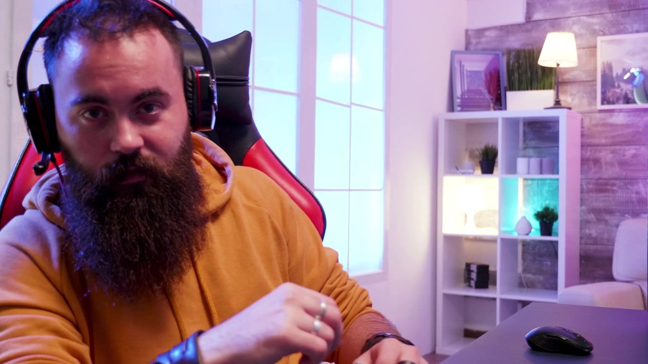 Gamer seduto guarda direttamente in camera dalla sua sedia