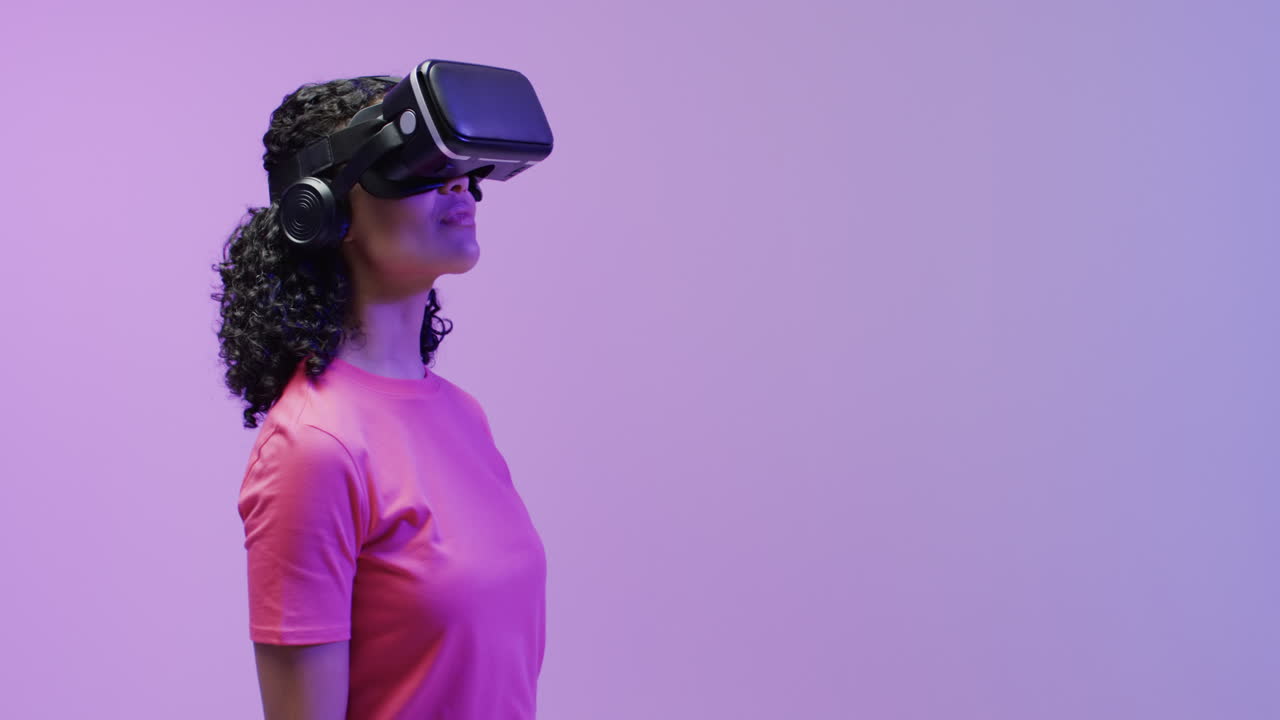 A young african american woman is immersed in a virtual reality experience, wearing a vr headset