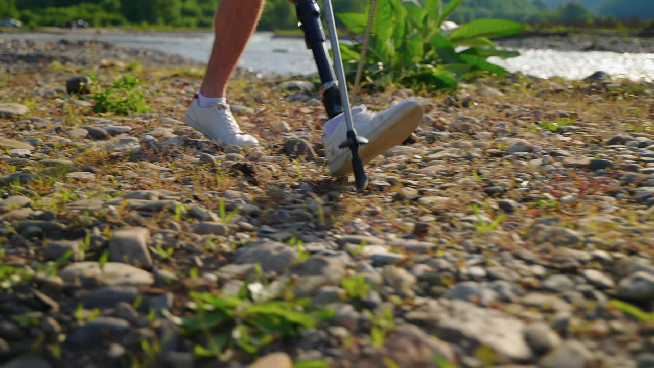 persona con una pierna protésica caminando cerca de un río
