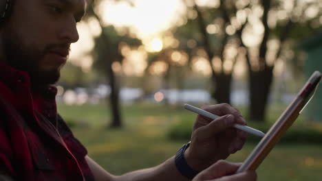 man drawing outdoors at sunset