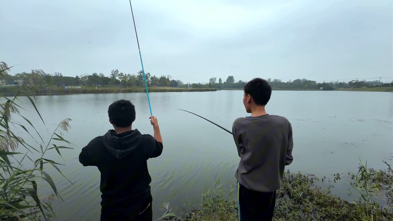 village boys fishing beside a beautiful lake in a village area of Chinese outskirts.