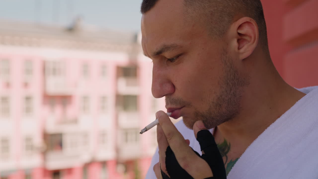 hombre atractivo fuma un cigarrillo pensando en la terraza del hotel