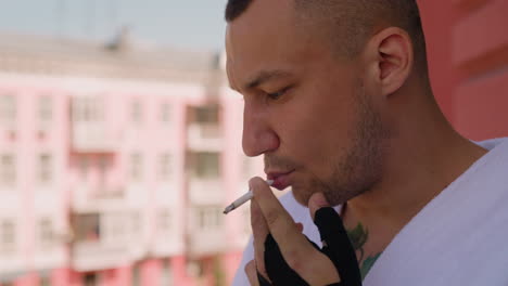 Attractive-man-smokes-cigarette-thinking-on-terrace-of-hotel