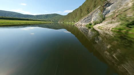 the mountains and glare of the sun are reflected in the water. extraordinarily beautiful nature. thick forests cover the steep slopes of high mountains. direction for travel.