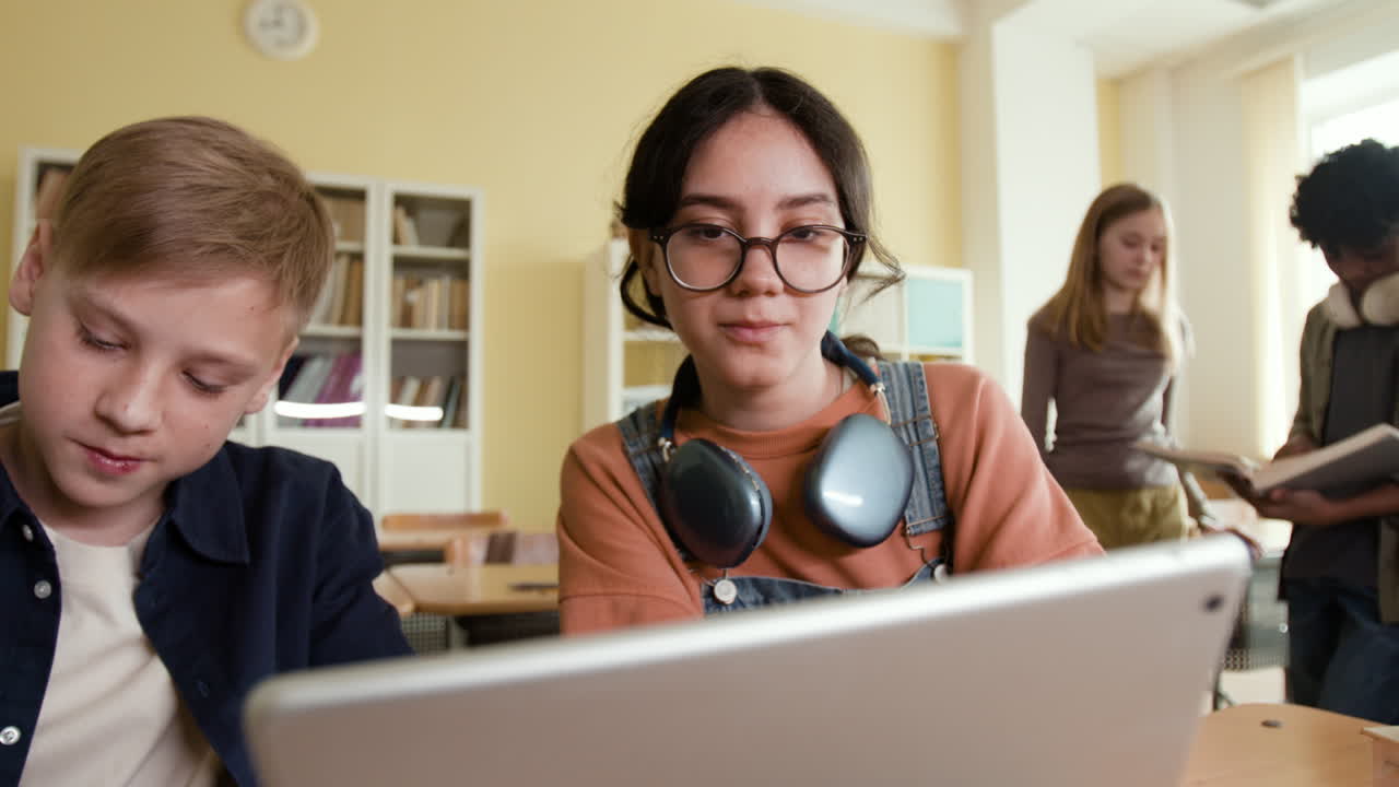 Students using a tablet in a classroom setting