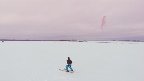 kitesurfing in the winter on snowboard or ski. skating on the ice in the wind. beautiful colored sails.